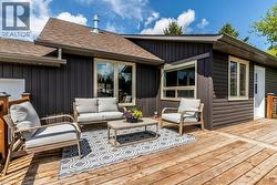 Spacious wooden deck extending from the property, featuring dark vertical siding and multiple windows - 