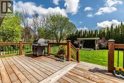 Expansive wood deck with a built-in railing system, overlooking a manicured lawn - 