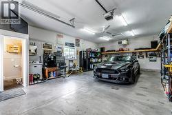 Spacious garage featuring concrete flooring and a ceiling-mounted fan - 