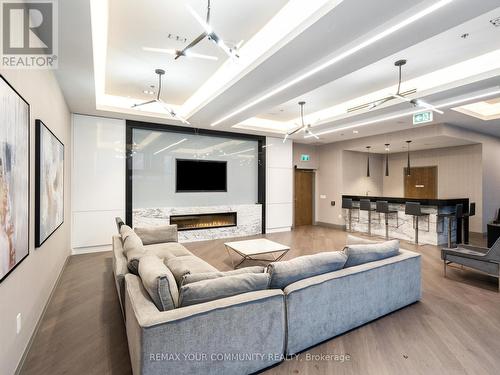 Large screen TV & Bar - 1012 - 99 Eagle Rock Way, Vaughan, ON - Indoor Photo Showing Living Room With Fireplace