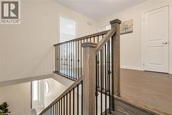 Staircase featuring wood-finish treads and handrails with black metal balusters - 