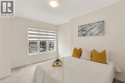 Windowed room featuring light wall paint, neutral carpeting, and a ceiling-mounted light fixture - 