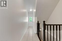 Entryway featuring light-toned tile flooring, white walls, and a white door with an upper glass pane - 