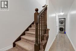 Carpeted staircase with dark wood-finish newel posts and handrail - 