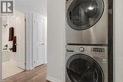 Integrated laundry area featuring stacked front-load machines - 