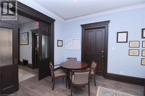 Spacious interior featuring dark wood-finish flooring, light blue wall paint, and elaborate dark wood trim - 108 George Street, Hamilton, ON 