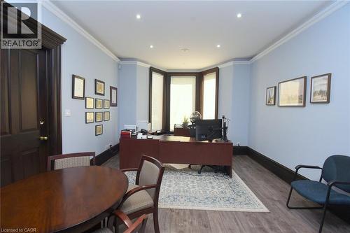 Spacious room featuring a bay window, recessed lighting, wood-finish flooring, and crown molding - 108 George Street, Hamilton, ON 
