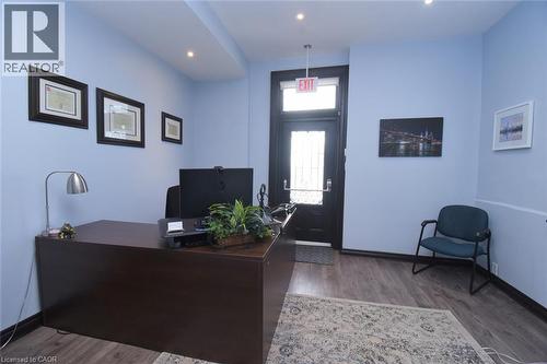Entry area featuring wood-finish flooring, recessed lighting, and a dark-toned door with a glass insert - 108 George Street, Hamilton, ON 