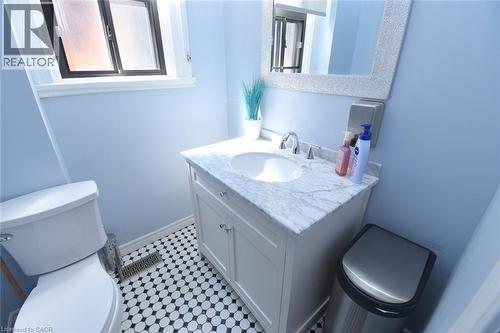Bathroom featuring a white vanity with a marble-finish countertop, undermount sink, and chrome faucet - 108 George Street, Hamilton, ON 