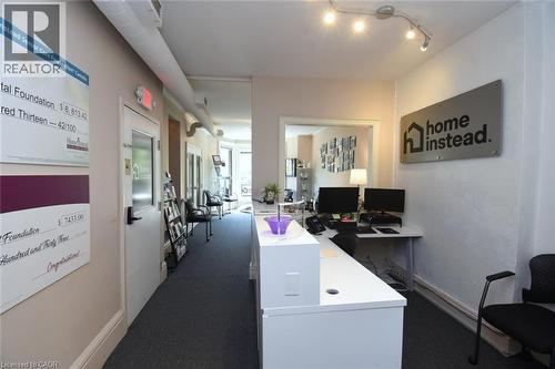 Reception area featuring a white counter, track lighting, and carpeted flooring - 108 George Street, Hamilton, ON 