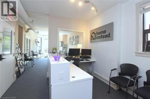 Reception area featuring a white desk, track lighting, and dark gray carpet - 108 George Street, Hamilton, ON 