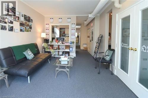 Open-concept reception area with durable gray carpeting and neutral wall tones - 108 George Street, Hamilton, ON 