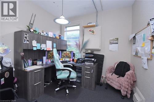 Dedicated office space featuring built-in cabinetry with wood-finish, a window providing natural light, and textured walls - 108 George Street, Hamilton, ON 