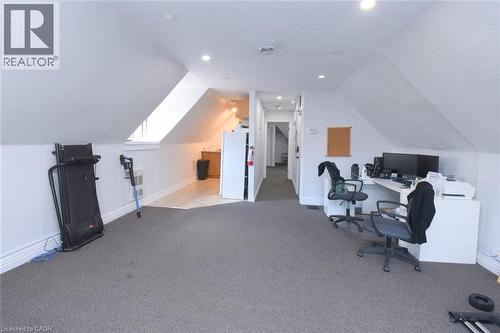 Spacious carpeted room featuring sloped ceilings and recessed lighting - 108 George Street, Hamilton, ON 