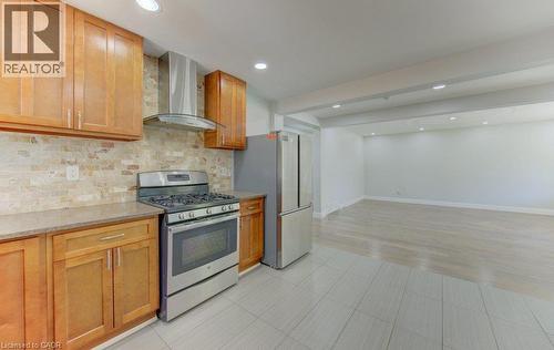 Kitchen featuring wood cabinetry, stone countertops, a tile backsplash, stainless steel appliances, and recessed lighting - 80 Lower Canada Crescent, Kitchener, ON - Indoor Photo Showing Kitchen