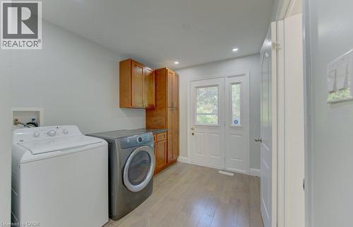 Dedicated utility area featuring wood-finish flooring, recessed lighting, double French doors with transom windows, and built-in cabinetry with a stone-look countertop - 80 Lower Canada Crescent, Kitchener, ON - Indoor Photo Showing Laundry Room