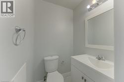Contemporary bathroom featuring a white vanity with integrated sink, framed mirror, and chrome fixtures - 