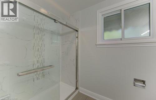 Glass-enclosed shower featuring white marble-look paneling and a decorative tile accent - 80 Lower Canada Crescent, Kitchener, ON - Indoor Photo Showing Other Room