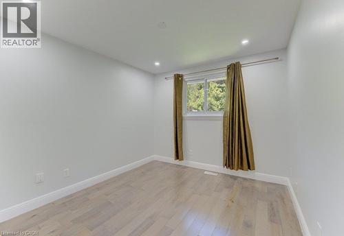 Bright interior space featuring light-toned wood-finish flooring, white walls, recessed ceiling lighting, and a double-pane window - 80 Lower Canada Crescent, Kitchener, ON - Indoor Photo Showing Other Room