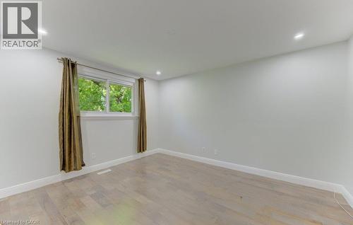 Light-filled interior space featuring wood-finish flooring, recessed lighting, white baseboards, and a large double-pane window - 80 Lower Canada Crescent, Kitchener, ON - Indoor Photo Showing Other Room