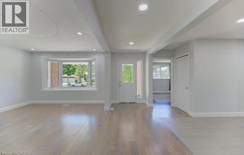 Open-concept living space with light wood-finish flooring, recessed lighting, a front entry door with glass paneling, and a bay window - 80 Lower Canada Crescent, Kitchener, ON - Indoor Photo Showing Other Room