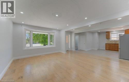 Expansive open-concept living area featuring light wood-finish flooring, recessed lighting, and a broad bay window - 80 Lower Canada Crescent, Kitchener, ON - Indoor Photo Showing Other Room