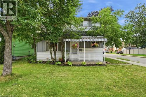 Two-story residence featuring light-colored siding and a covered front porch with a striped awning - 432 Upper Sherman Avenue, Hamilton, ON - Outdoor
