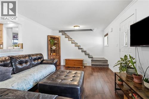 Living area featuring rich wood-finish flooring, white painted walls, and a staircase with open risers - 432 Upper Sherman Avenue, Hamilton, ON - Indoor Photo Showing Living Room