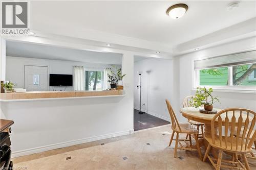 Dining area featuring light-toned square tile flooring with dark accent squares, a rectangular window with roller blinds, and a semi-flush mount ceiling light fixture - 432 Upper Sherman Avenue, Hamilton, ON - Indoor Photo Showing Dining Room