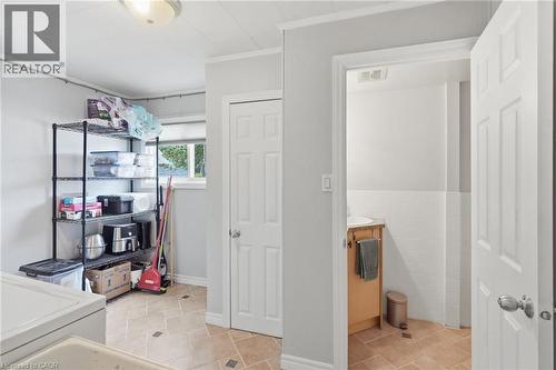Utility space featuring durable tile flooring, a window providing natural light, and a white paneled door - 432 Upper Sherman Avenue, Hamilton, ON - Indoor Photo Showing Laundry Room