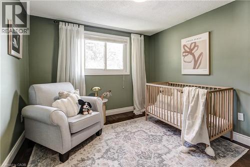 Room featuring a single window with white trim, dark wood-finish flooring, light green painted walls, and a textured white ceiling - 323 Cranbrook Drive, Hamilton, ON - Indoor