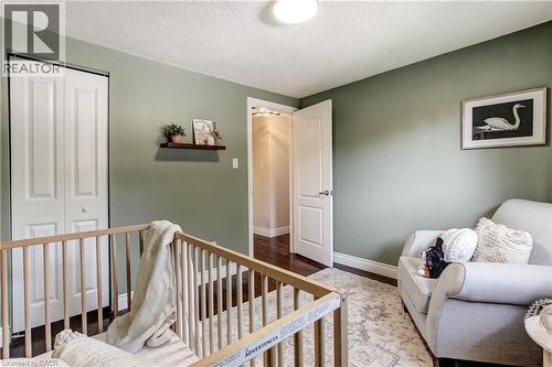 Room featuring a neutral wall color, white bi-fold closet doors, a white paneled interior door, dark wood-finish flooring, and a ceiling-mounted light fixture - 323 Cranbrook Drive, Hamilton, ON - Indoor