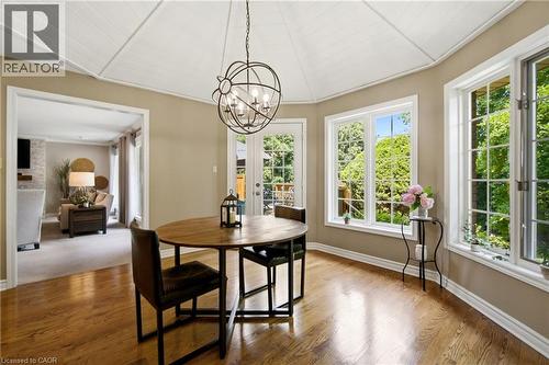 Dining area featuring wood-finish flooring, a white paneled cathedral ceiling, and an ornate spherical chandelier - 1090 Crofton Way, Burlington, ON - Indoor Photo Showing Dining Room