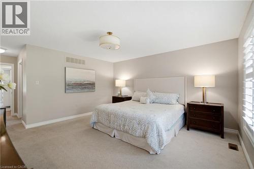Carpeted room featuring a ceiling-mounted light fixture, recessed lighting, and white plantation shutters - 1090 Crofton Way, Burlington, ON - Indoor Photo Showing Bedroom