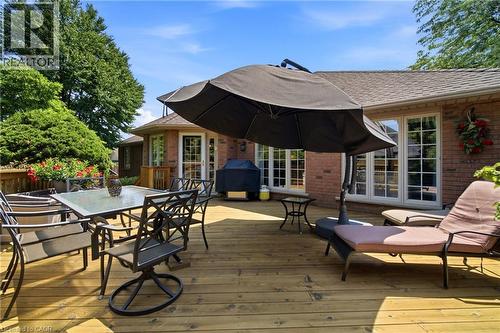 Spacious wood-finish deck featuring a red brick exterior, multiple sets of French doors, and mature perimeter landscaping - 1090 Crofton Way, Burlington, ON - Outdoor With Deck Patio Veranda With Exterior