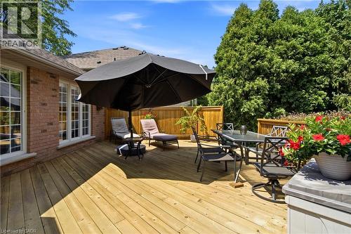 Expansive wood deck with a privacy fence, featuring a brick exterior with multiple windows, and dense evergreen landscaping - 1090 Crofton Way, Burlington, ON - Outdoor With Deck Patio Veranda With Exterior