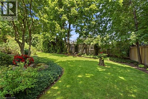 Expansive rear yard featuring a manicured lawn, established trees, mature perimeter plantings, and natural wood fencing - 1090 Crofton Way, Burlington, ON - Outdoor