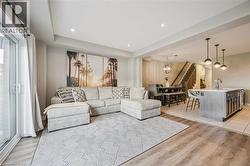 Open-concept living area featuring wood-finish flooring, recessed lighting, and a sliding glass door - 