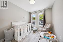 Room featuring two windows, light gray walls, wood-finish flooring, a white ceiling, and a flush-mount light fixture - 