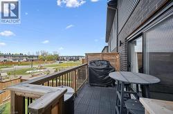 Private outdoor balcony featuring composite deck tile flooring and a dark wood railing - 