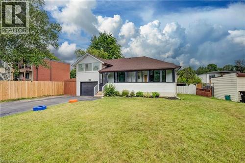 Single-story property featuring a white exterior, brown shingle roof, and an attached garage with a dark door - 182 Avalon Place, Kitchener, ON - Outdoor