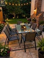 Expansive patio featuring stamped concrete, string lighting, and extensive perimeter landscaping - 