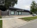 Commercial building with gray horizontal siding and a dark roofline - 116 St Clair Avenue, Kitchener, ON 