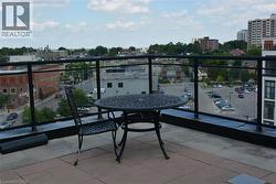 Outdoor terrace with tile flooring and a black metal railing - 