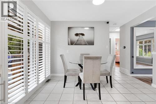White louvered patio doors with horizontal slats, light gray painted walls, and white square floor tiles - 744 Birchwood Avenue, Cambridge, ON - Indoor Photo Showing Dining Room