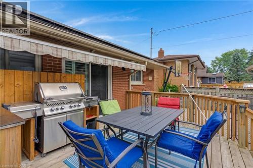 Expansive wood deck featuring a protective awning, a built-in outdoor grill station, a functional outdoor table, and a wooden railing system - 744 Birchwood Avenue, Cambridge, ON - Outdoor With Deck Patio Veranda With Exterior