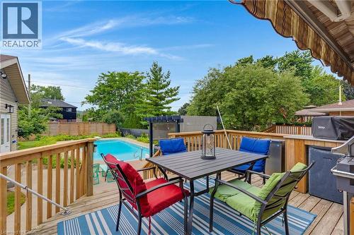 Expansive backyard featuring a large in-ground swimming pool, a spacious wood deck, and mature perimeter landscaping - 744 Birchwood Avenue, Cambridge, ON - Outdoor With Deck Patio Veranda With Exterior