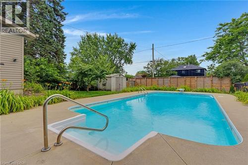 Rectangular swimming pool featuring concrete decking and a chrome handrail - 744 Birchwood Avenue, Cambridge, ON - Outdoor With In Ground Pool With Backyard