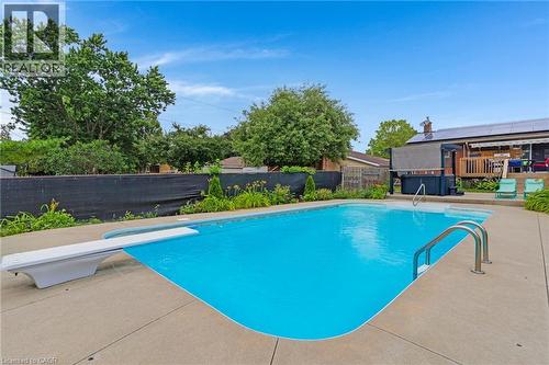In-ground pool featuring a diving board and stainless steel handrails - 744 Birchwood Avenue, Cambridge, ON - Outdoor With In Ground Pool With Backyard