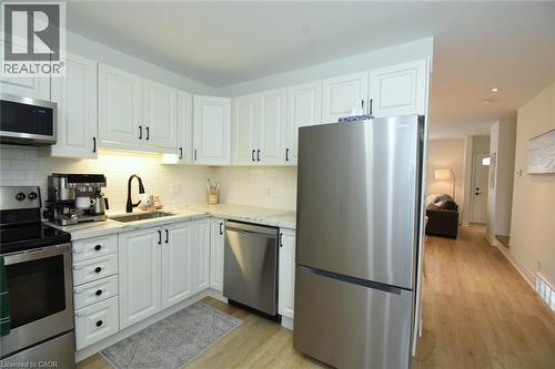 Modern kitchen featuring white shaker-style cabinetry, stainless steel appliances, a subway tile backsplash, and light-toned countertops - 106 Belview Avenue, Hamilton, ON - Indoor Photo Showing Kitchen With Stainless Steel Kitchen With Upgraded Kitchen